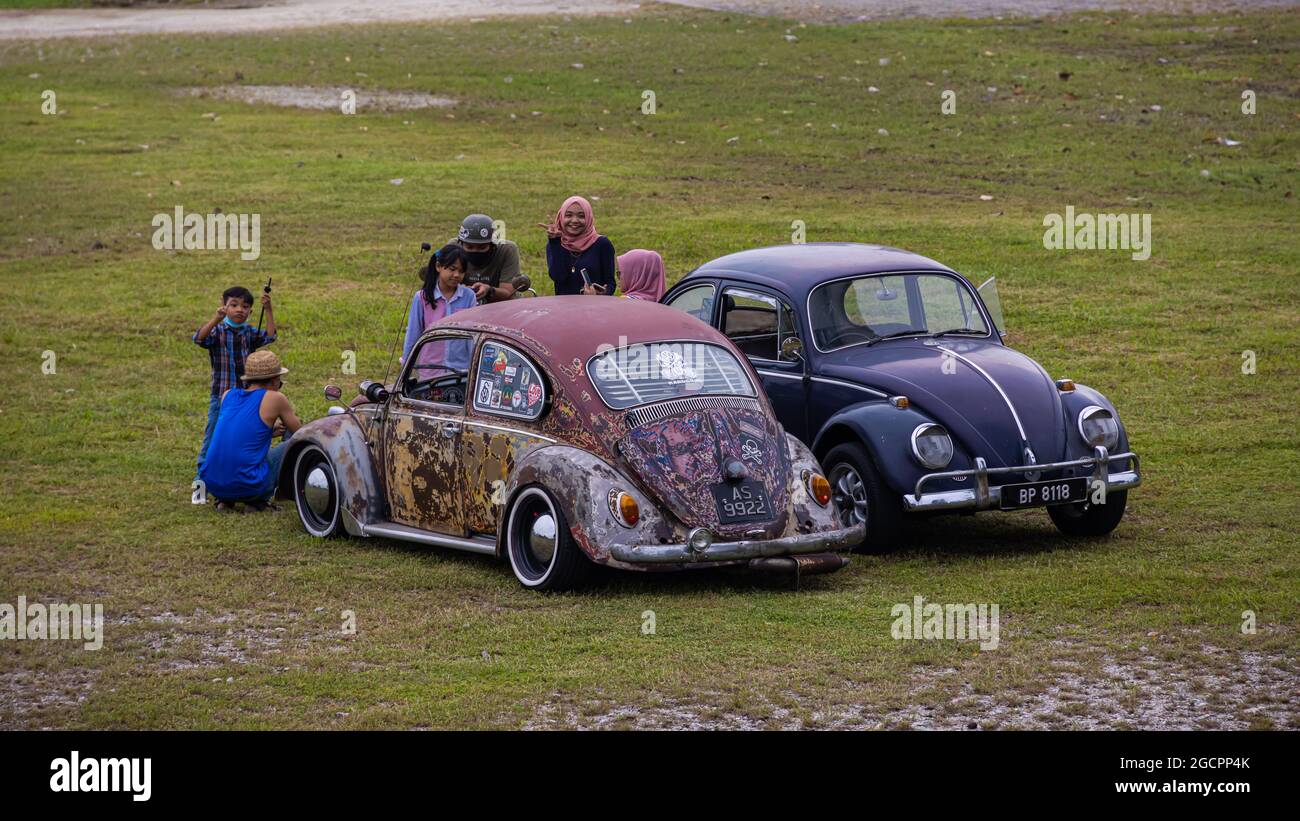 Putrajaya, Malaysia - October 11, 2020: Two Malay families meet with their old Volkswagen Beetle in a Park in Putrajaya. Two well restored VW Beetles Stock Photo