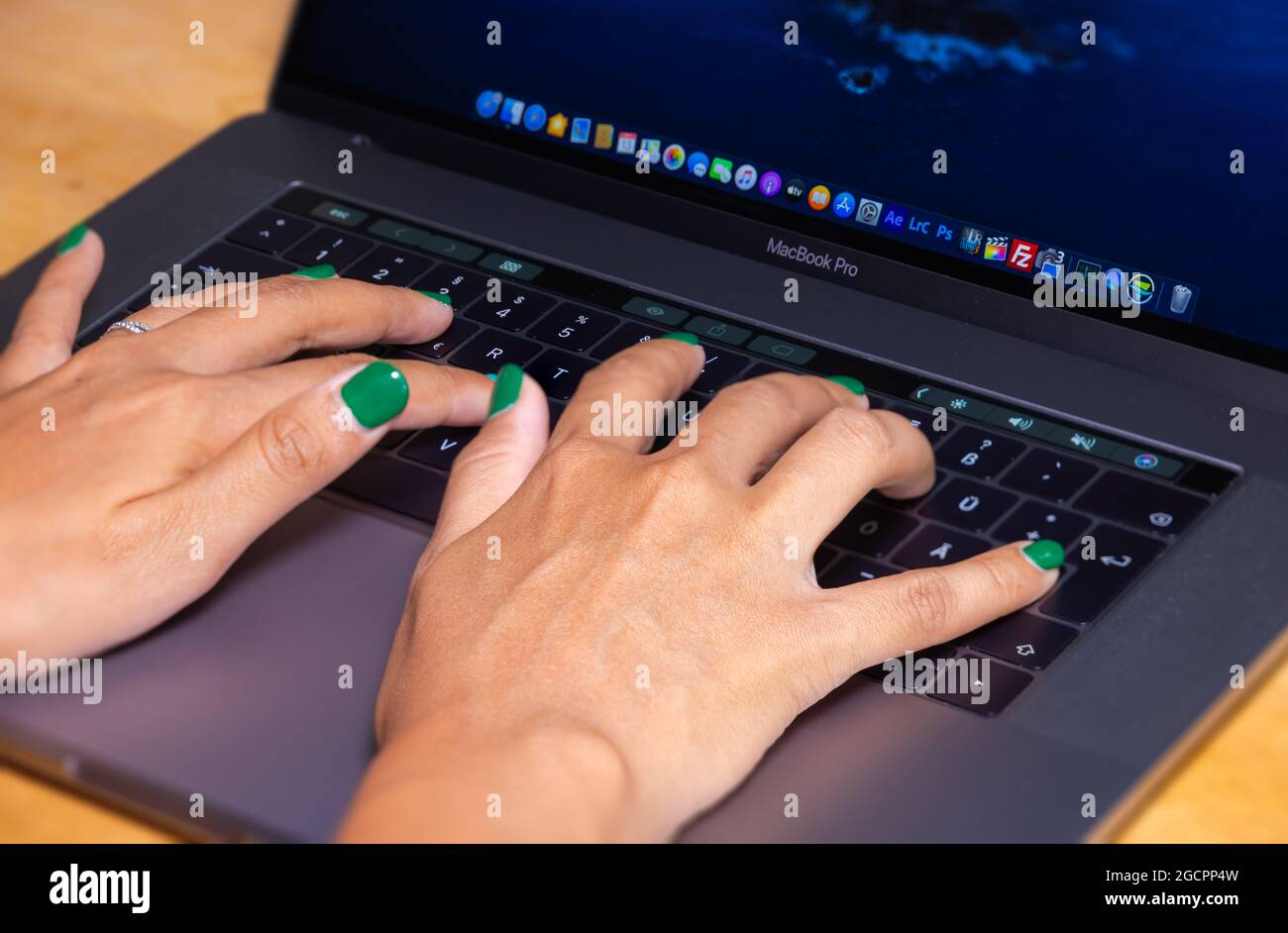 Cyberjaya, Malaysia - October 13, 2020:  Woman hands typing on a computer keyboard. Female hands writing on a laptop keyboard. Fingernails are painted Stock Photo