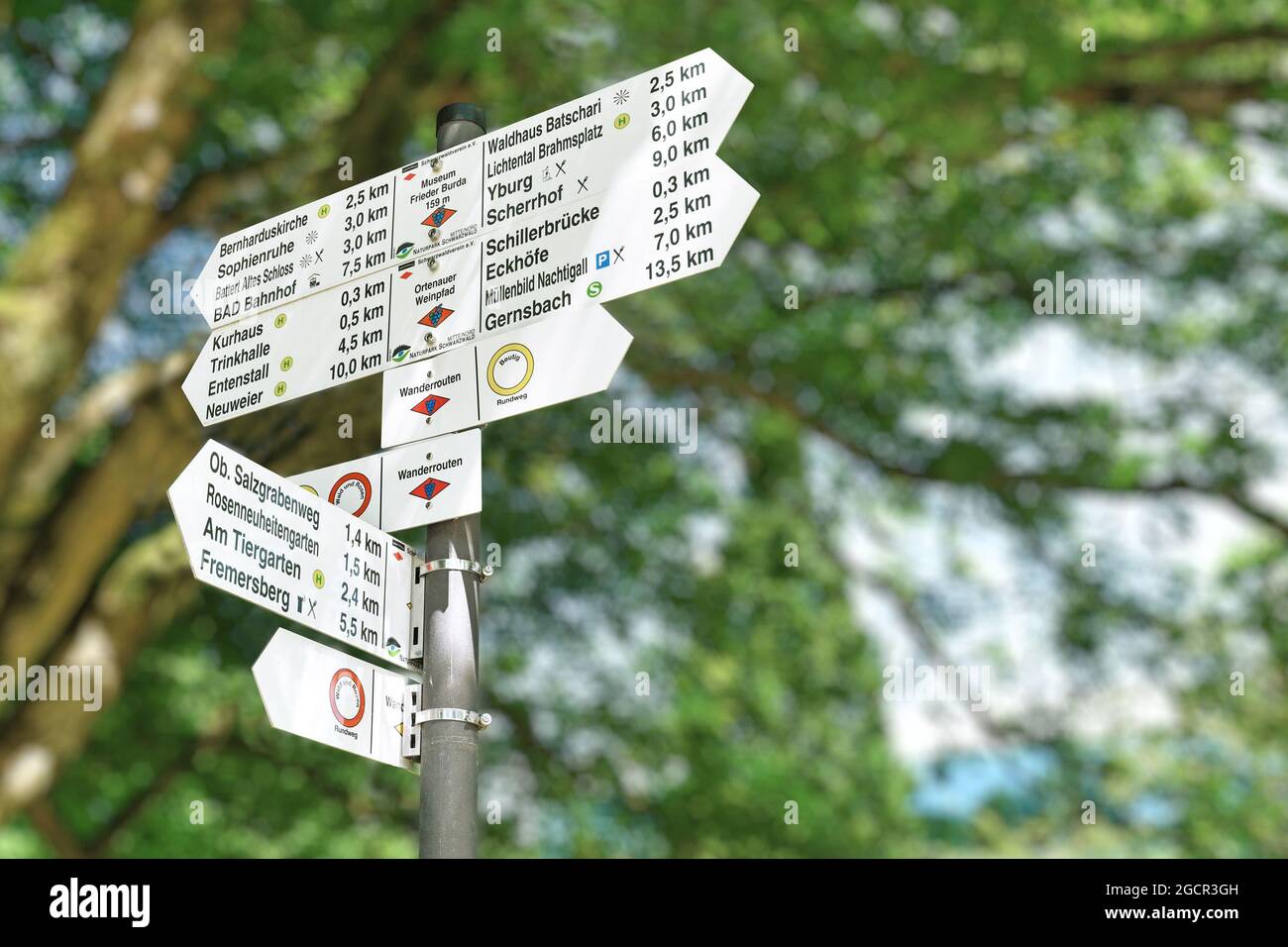 Baden-Baden, Germany - July 2021: Signpost with signs showing directions and distance to various sight seeing place of interest in world heritage site Stock Photo