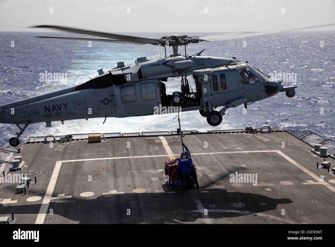 210721-N-RL695-1246   CARIBBEAN SEA - (July 21, 2021) -- Sailors assigned to the Freedom-variant littoral combat ship USS Sioux City (LCS 11) attach a cargo load of 575 kilograms of suspected contraband to an MH-60S Seahawk helicopter attached to the “Sea Knights” of Helicopter Sea Combat Squadron (HSC) 22, Detachment 3, for transfer to the Freedom-variant littoral combat ship USS Billings (LCS 15), July 21, 2021. Sioux City is deployed to the U.S. 4th Fleet area of operations to support Joint Interagency Task Force South’s mission, which includes counter-illicit drug trafficking missions in t Stock Photo
