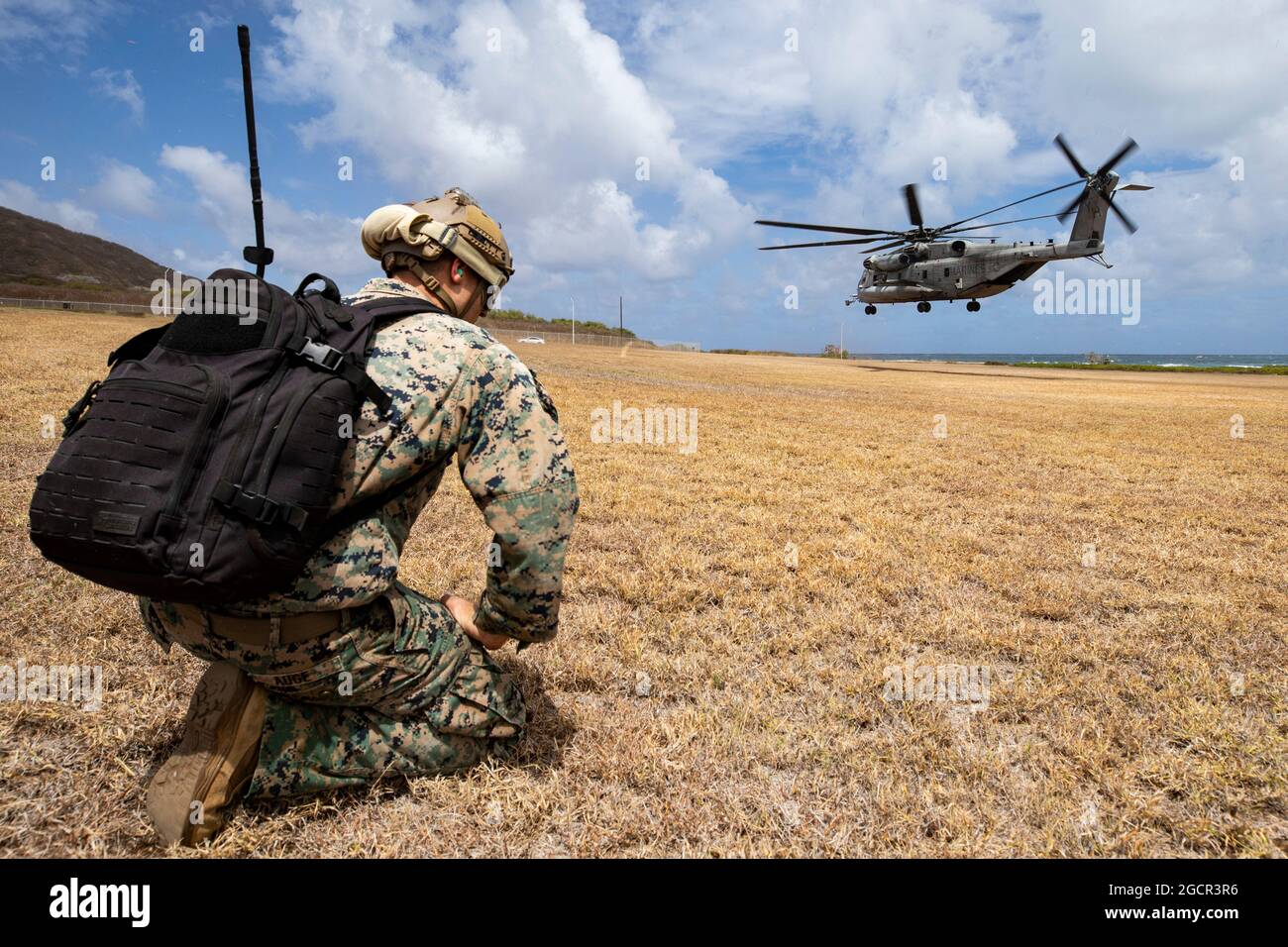 U.S. Marine Corps Sgt. Marcus Auge, air delivery specialist, 3rd Radio Battalion, awaits a CH-53E Super Stallion attached to Marine Heavy Helicopter Squadron 463 during helicopter rope suspension techniques training, Landing Zone Eagle, Marine Corps Base Hawaii, Aug. 6, 2021. As a host platform to all elements of the Marine Air Ground Task Force, MCBH provides the necessary environment to produce readiness in the air, on land and at sea. (U.S. Marine Corps photo by Lance Cpl. Samantha Sanchez) Stock Photo