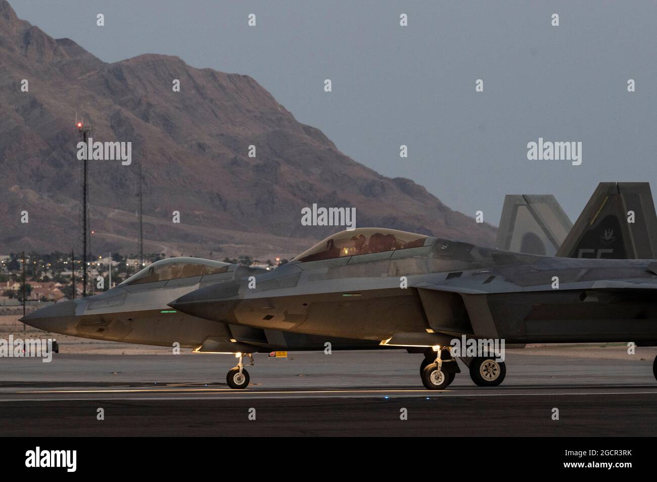 Two F-22 Raptors assigned to the 1st Fighter Wing, Langley Air Force Base, Virginia, line up prior to take-off for a night-training mission during Red Flag-Nellis 21-3 at Nellis Air Force Base, Nevada, Aug. 4, 2021. The 1st FW hosted RF-Nellis 21-3 as the lead wing with nearly 100 aircraft, such as the F-35, F-35, F-22, F-16CJ, F-16C, EC-130H, EA-18G, B-52, B-2, F/A-18 C/D, MQ-9, E-3, E-8, RC-135, RQ-4B30, RQ-4B40, U-2, HH-60, HC-130, KC-135 and KC-46, that participated in complex-mission scenarios against aggressor forces. (U.S. Air Force photo by Tech. Sgt. Alexandre Montes) Stock Photo