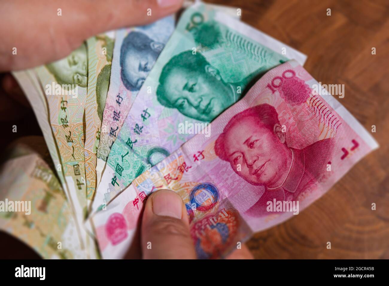 Male hand shows Renminbi or Chinese yuan  or abbreviated RMB banknote, the official currency of the peoples republic of china. On front side the portr Stock Photo