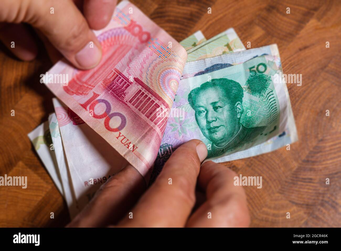 Male hand shows Renminbi or Chinese yuan  or abbreviated RMB banknote, the official currency of the peoples republic of china. On front side the portr Stock Photo