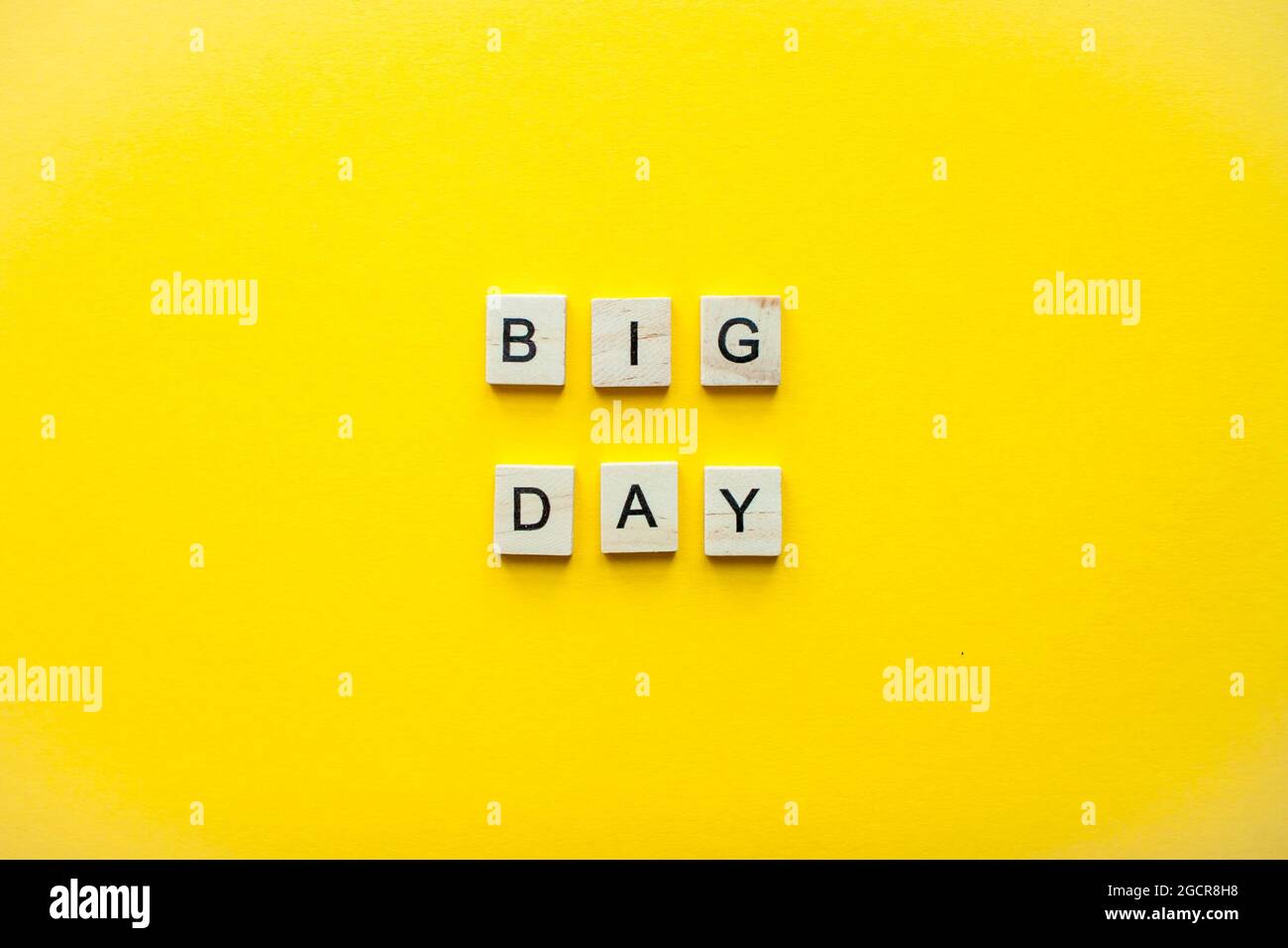 The inscription big day from wooden blocks on a bright yellow background Stock Photo