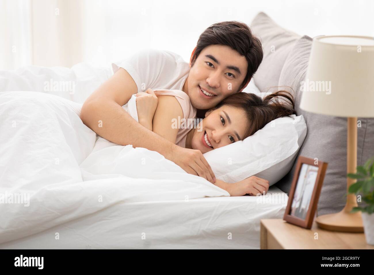 Young couple waking up in bed Stock Photo
