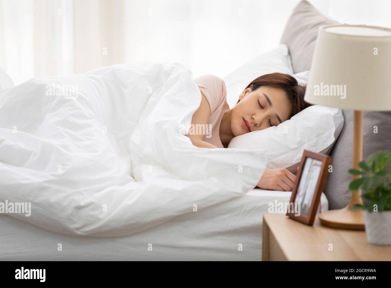 Young woman sleeping in bed Stock Photo - Alamy