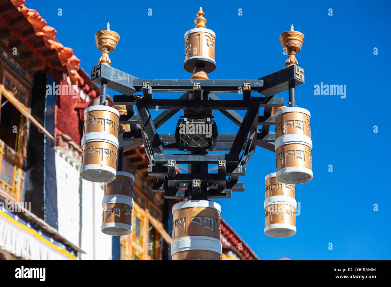 Lhasa, Tibet, China - November 15, 2019:  Buddhist prayer drums on the  bakuo road around the Jokhang Temple. People walking this street clockwise for Stock Photo