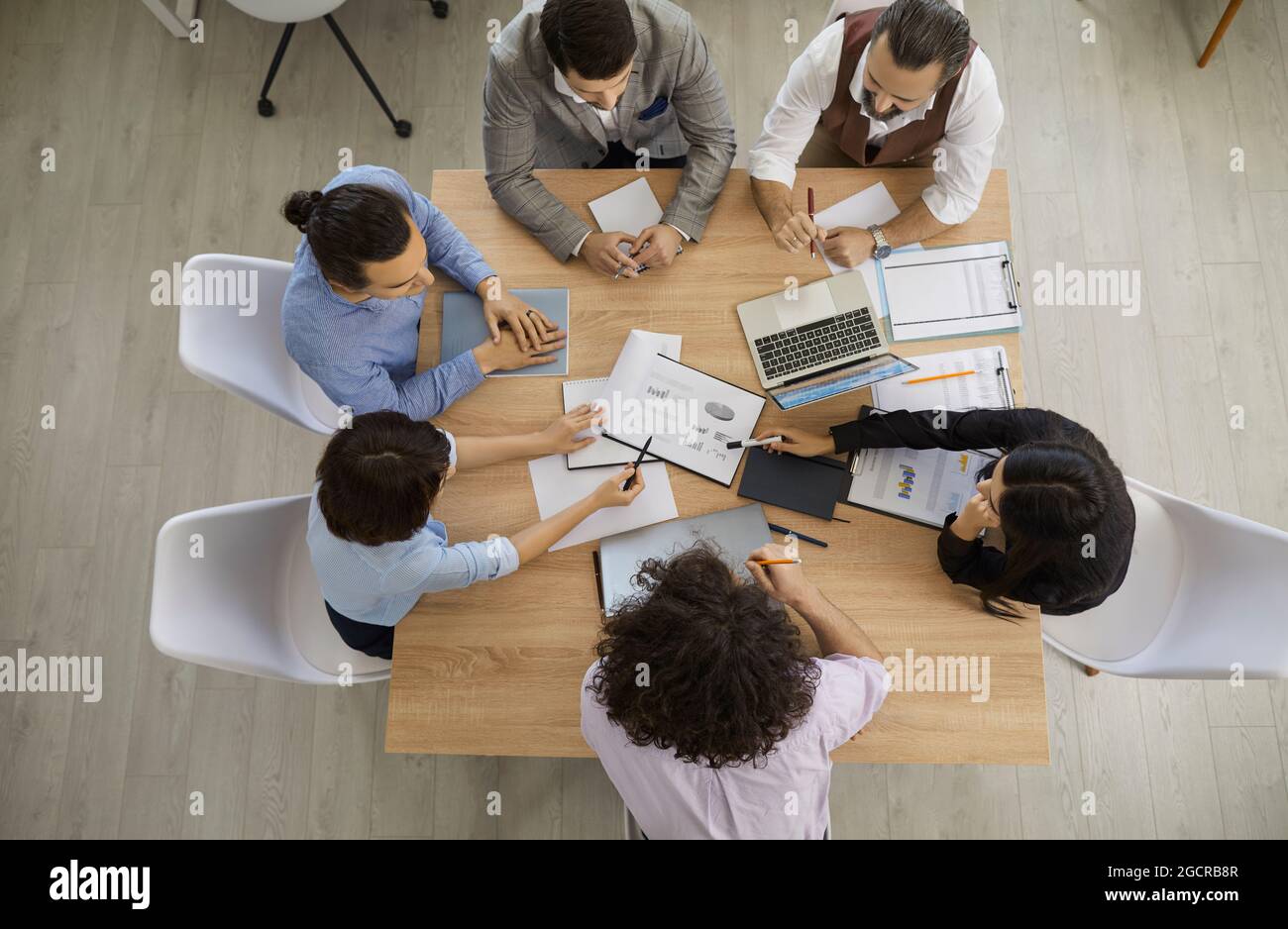 Top view of team of people having discussion during business meeting around office table Stock Photo