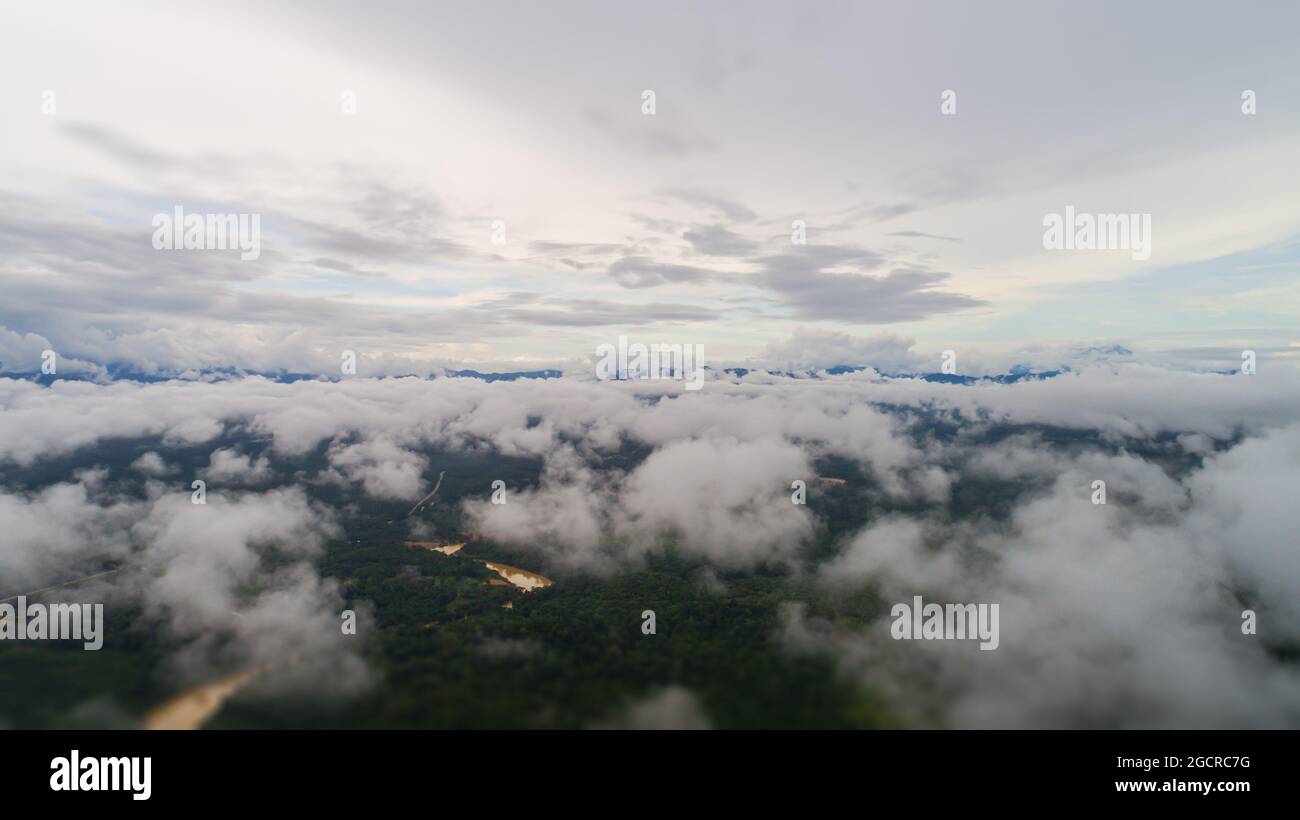 Aerial view over the landscape at the rock of Gua Charas, Pahang, Malaysia, near the east coast of Malaysia and the town of Kuantan. Over the clouds a Stock Photo