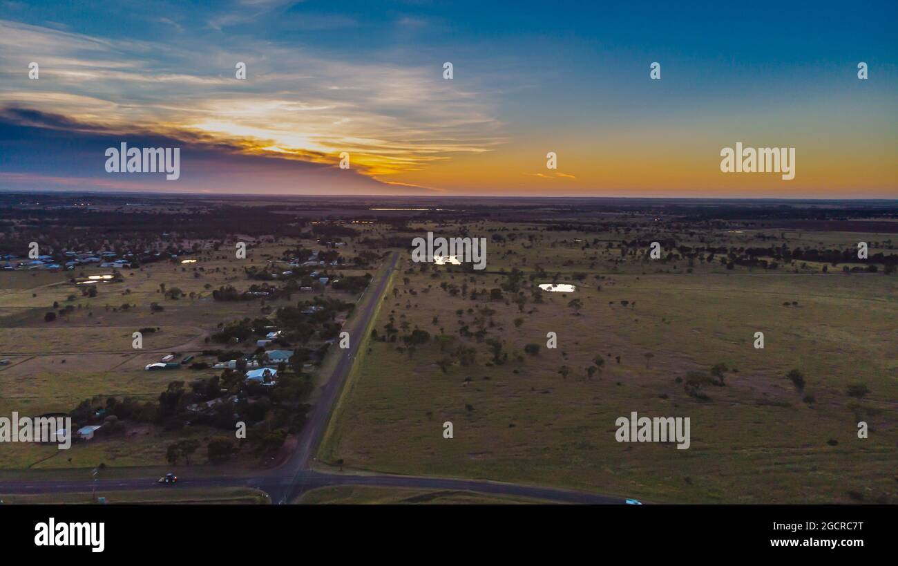 Aerial view during sunrise over the Australian outback near the village of Roma, Queensland, Australia. A drone view of the rising sun over the open f Stock Photo