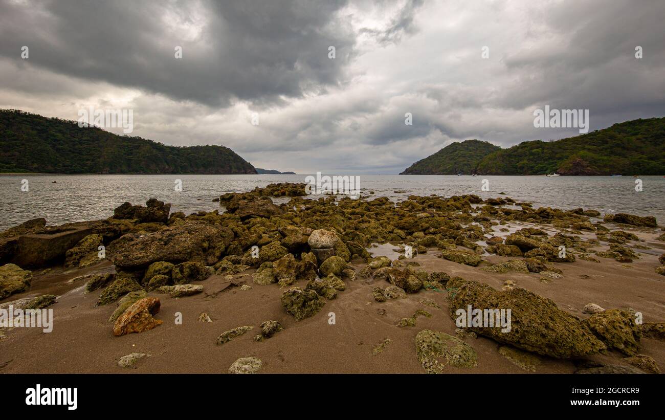 Rocks at the beach at La Primavera, Philippines. Stony shore on a cloudy day in the lagoon. The riff in the bay with the wide angle view to the pacifi Stock Photo
