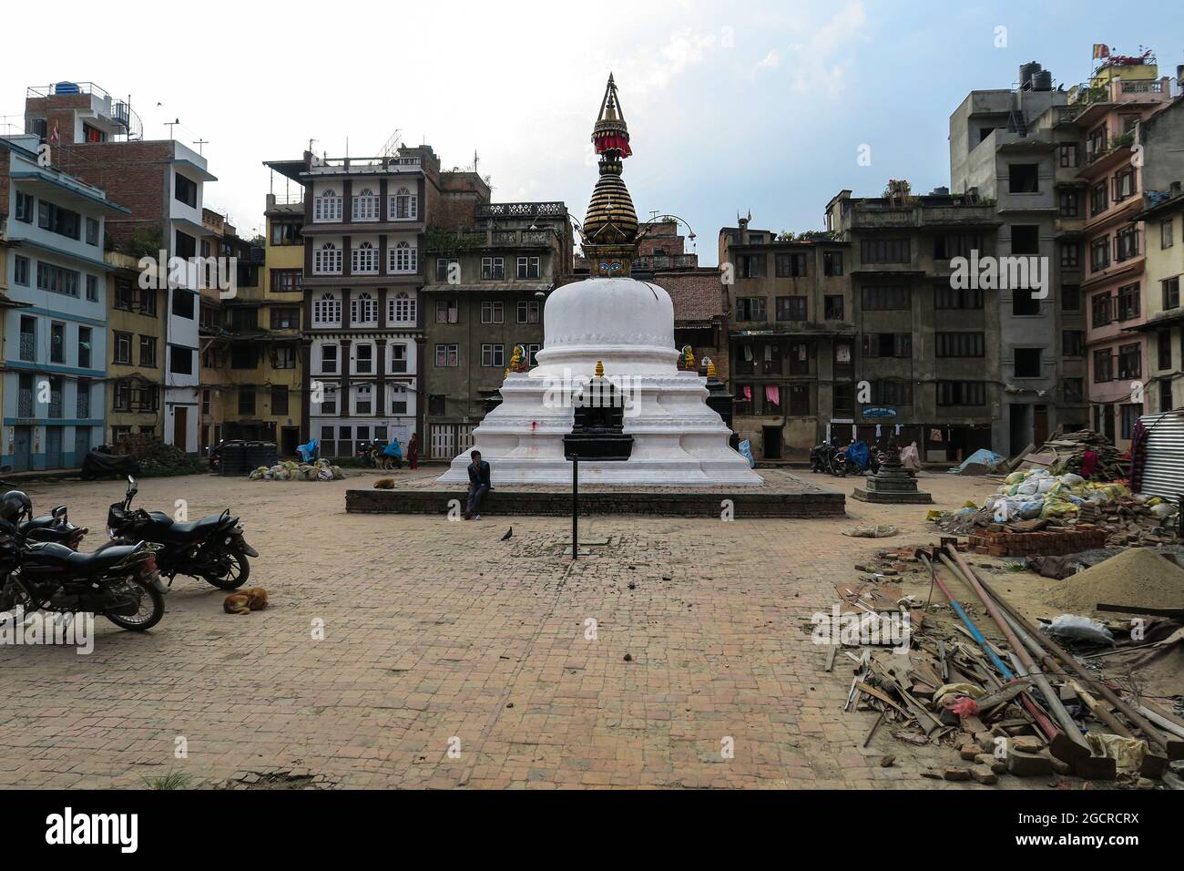 Kathmandu, Nepal - November 12, 2020 - Stupa in a shabby residential area. Residential buildings houses are still marked by the earthquake. Garbage an Stock Photo