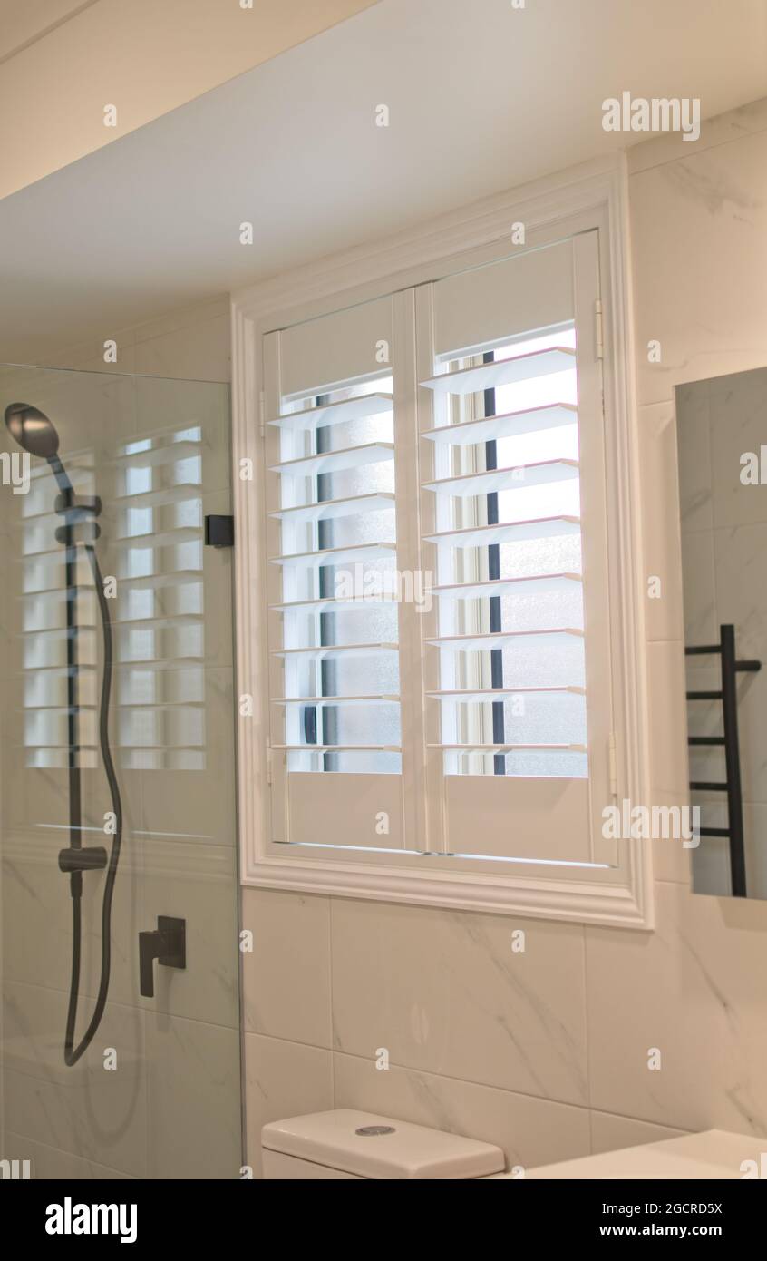 Luxury white plantation shutters in bathroom Stock Photo Alamy