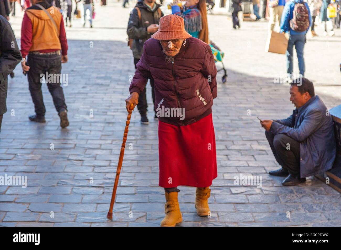 Lhasa, Tibet, China - November 15, 2020:  Old Tibetan men in traditional Tibetan clothes and walking stick. For prayer purpose people walking on the Stock Photo