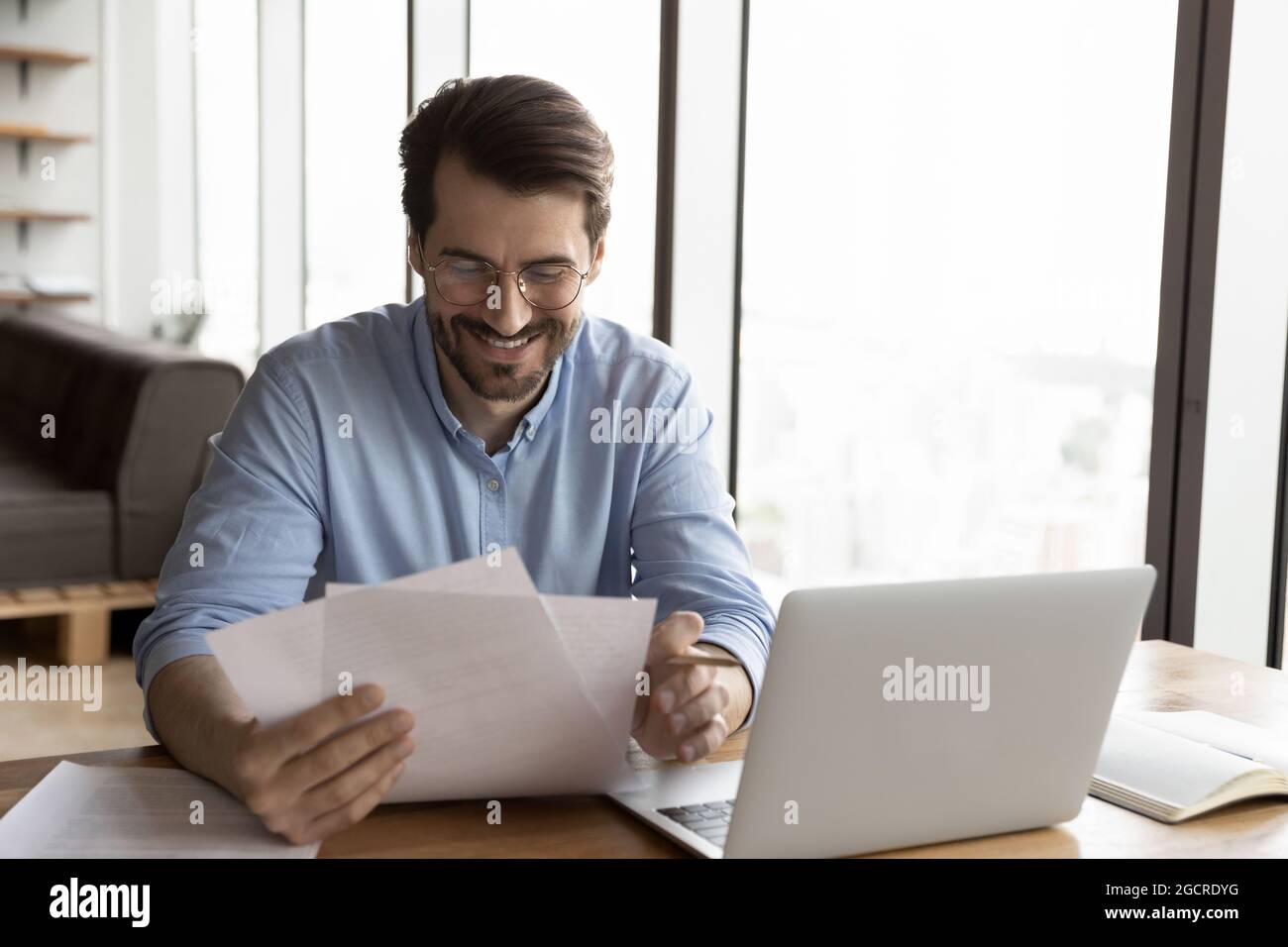 Happy business professional in glasses reviewing official legal documents Stock Photo
