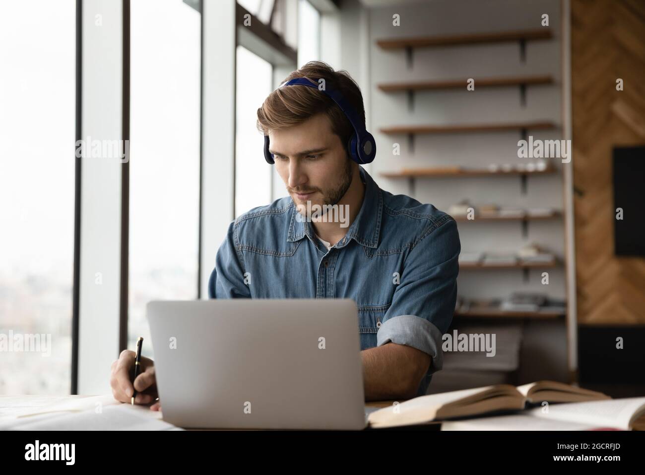 Focused adult student guy in headphones listening to learning seminar Stock Photo