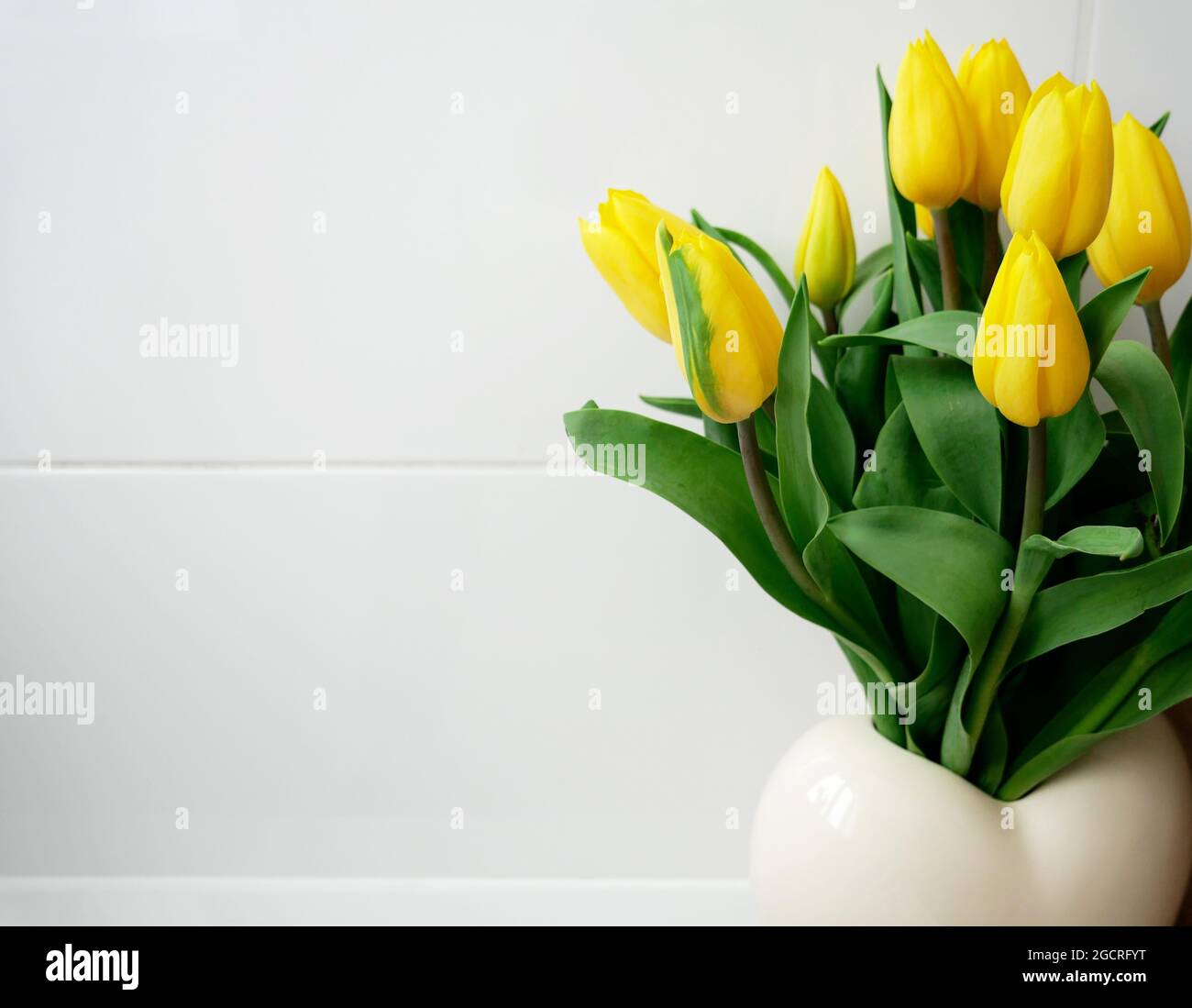Bunch of yellow tulips in a vase Stock Photo - Alamy