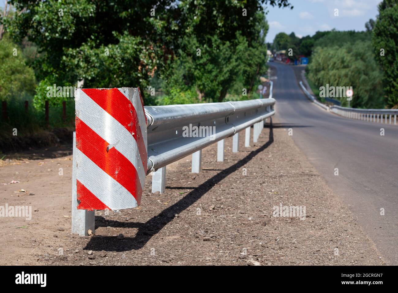 red road reflectors along the road. metal road fencing of barrier type