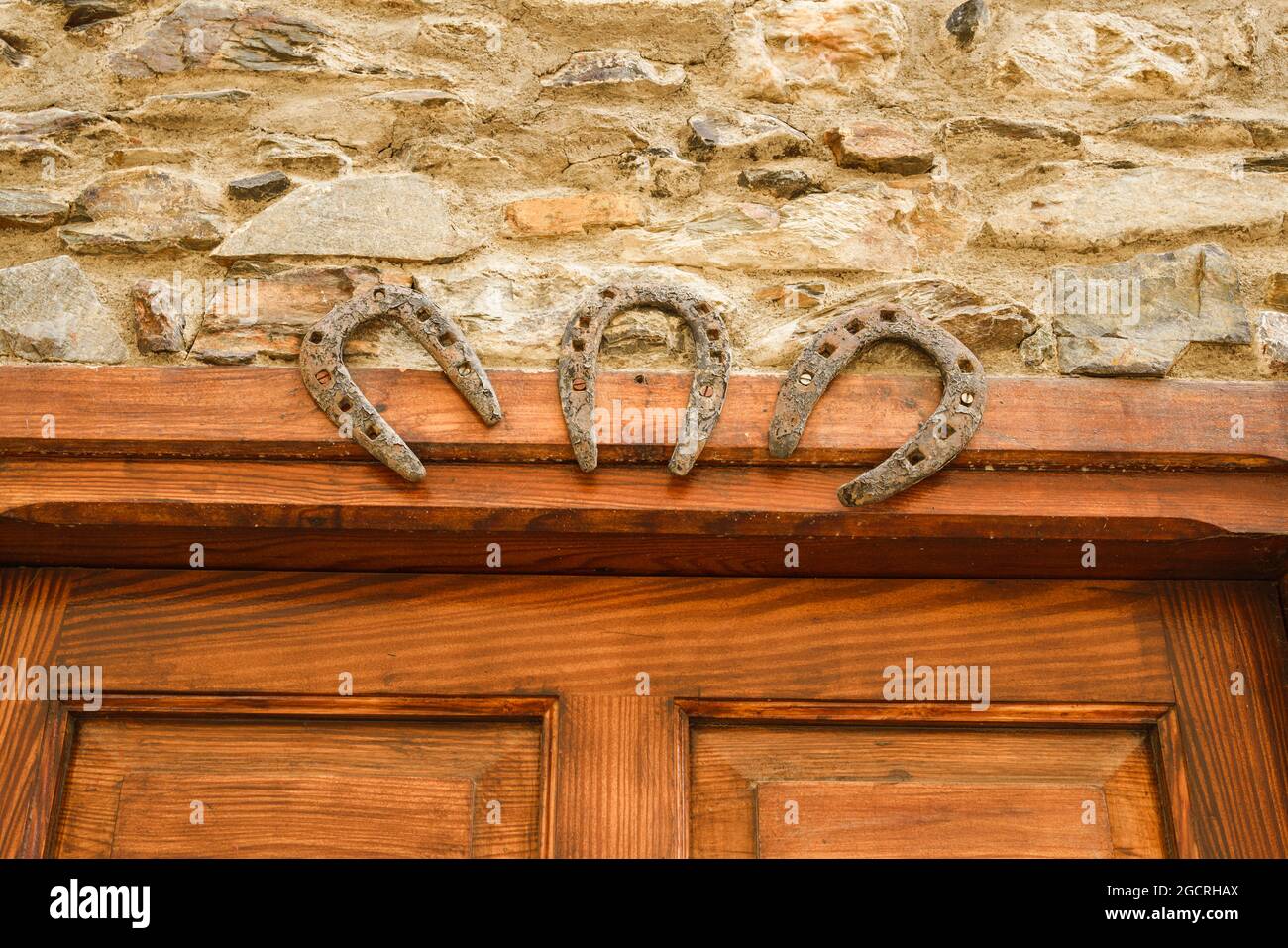 Three iron horseshoes for good luck symbols on a wooden door. Talisman