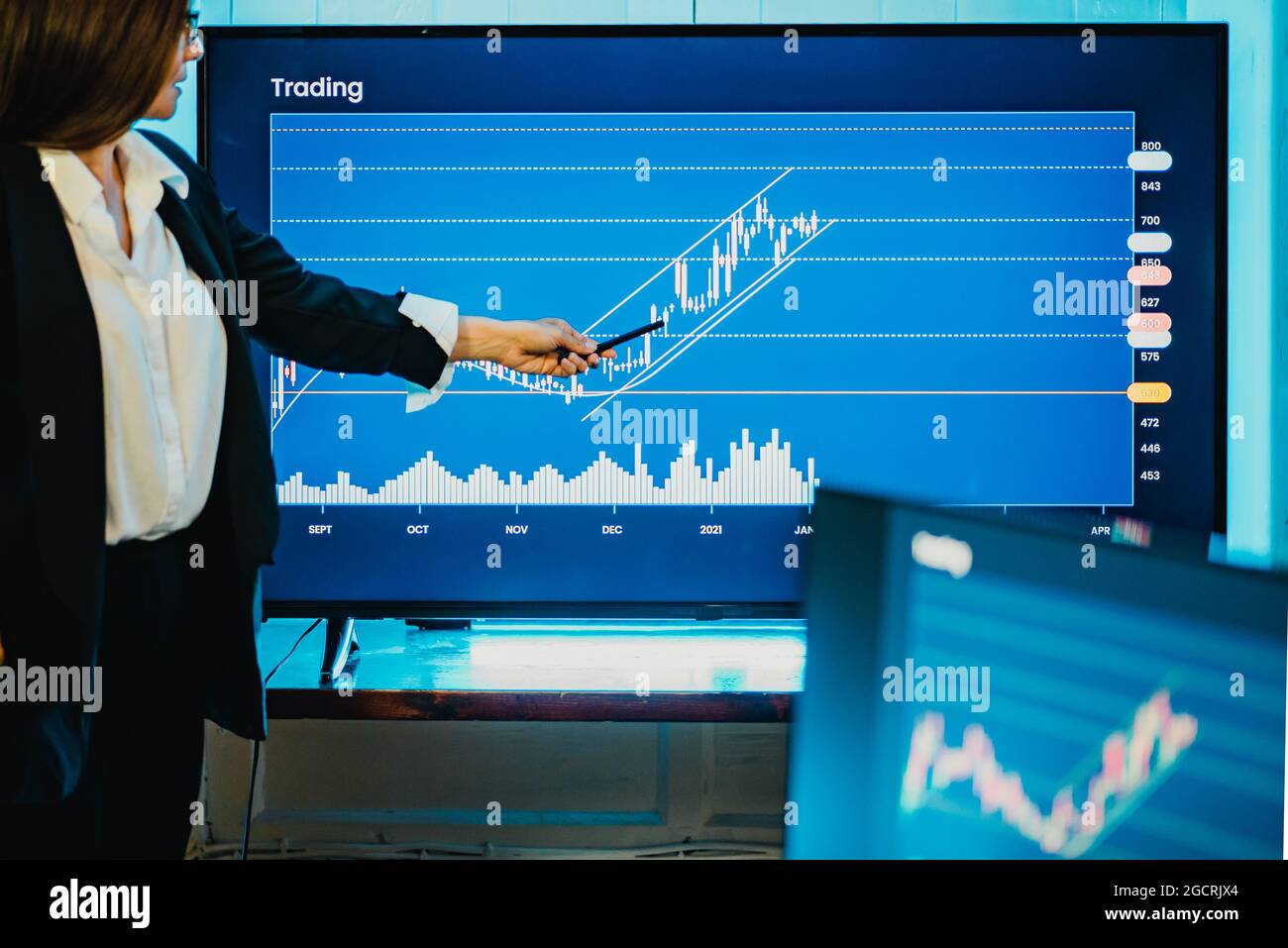 Mature business woman doing stock market exchange presentation at bank