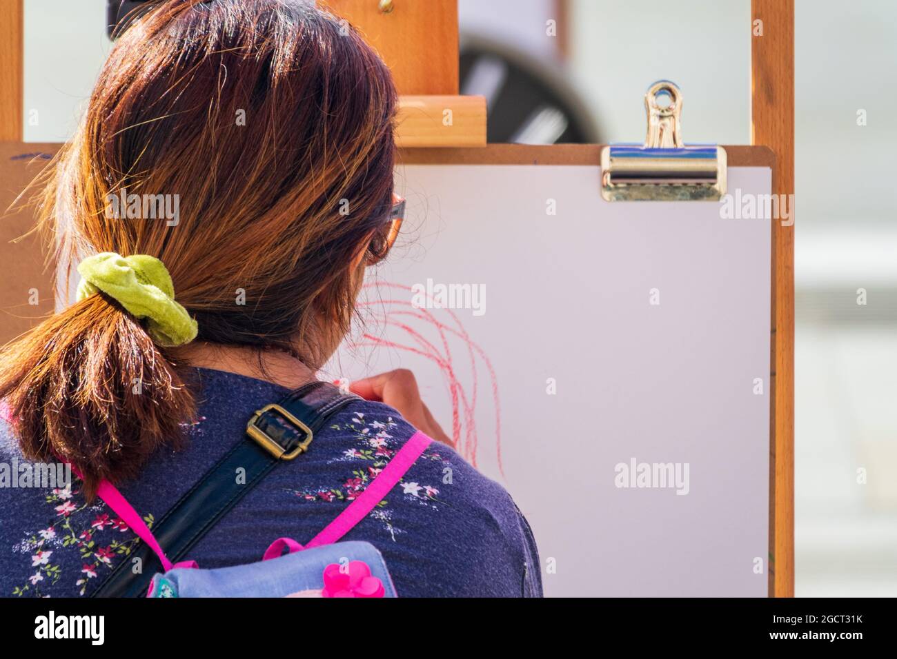 Rear view of a woman sketching on an art easel as part of the National ...