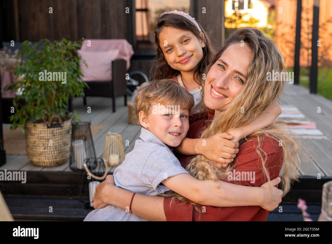 Happy family of mother, son and daughter relaxing in front of camera on weekend Stock Photo