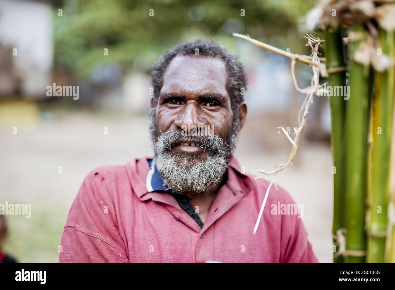 PORT MORESBY, PAPUA NEW GUINEA - May 06, 2018: A senior man from New Guinea wearing a red shirt Stock Photo