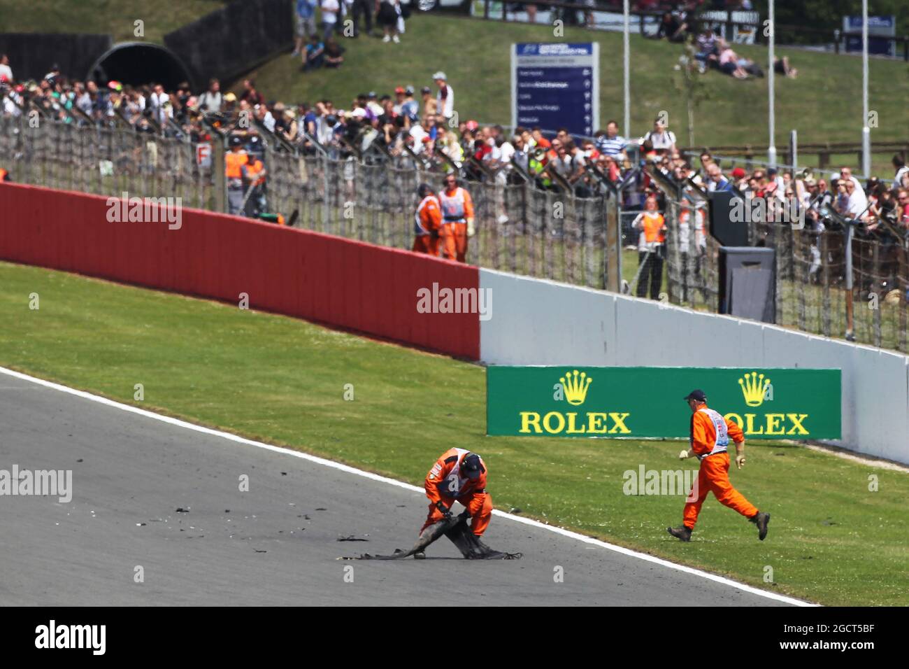 Marshals come on to the track to remove debris from the circuit. British Grand Prix, Sunday 30th