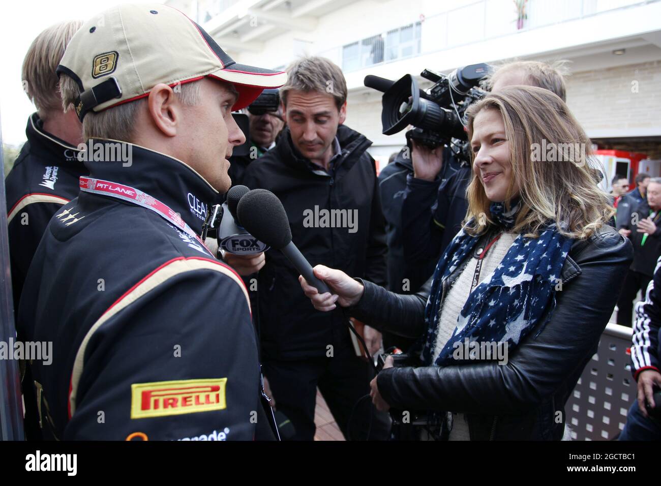 Heikki Kovalainen (FIN) Lotus F1 Team with Jennie Gow (GBR) BBC Radio 5 Live Pitlane Reporter and the media