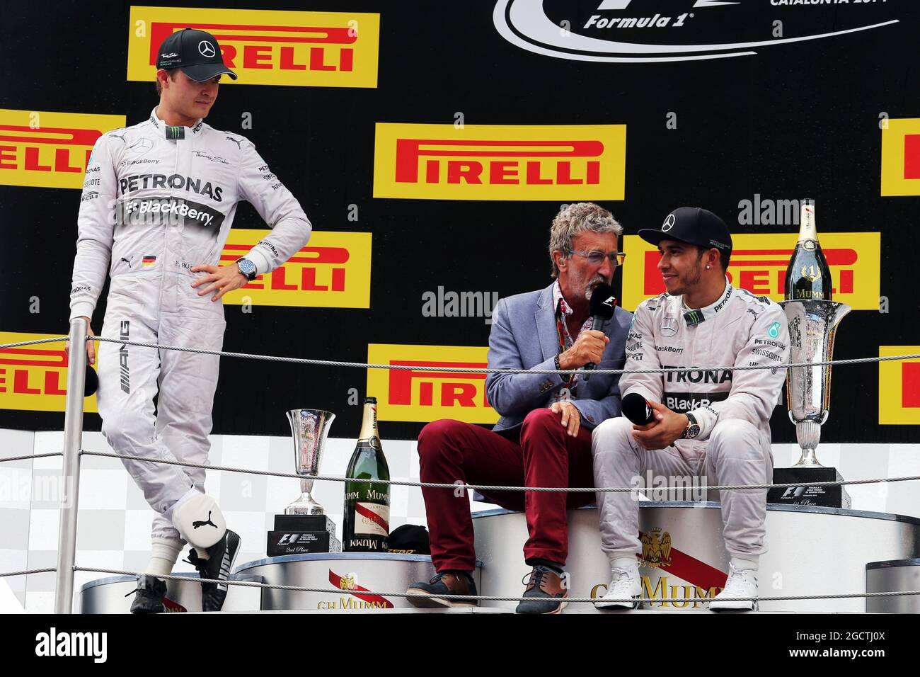 (L to R): Nico Rosberg (GER) Mercedes AMG F1 on the podium with Eddie Jordan (IRE) BBC Television Pundit and race winner Lewis Hamilton (GBR) Mercedes AMG F1. Spanish Grand Prix, Sunday 11th May 2014. Barcelona, Spain. Stock Photo