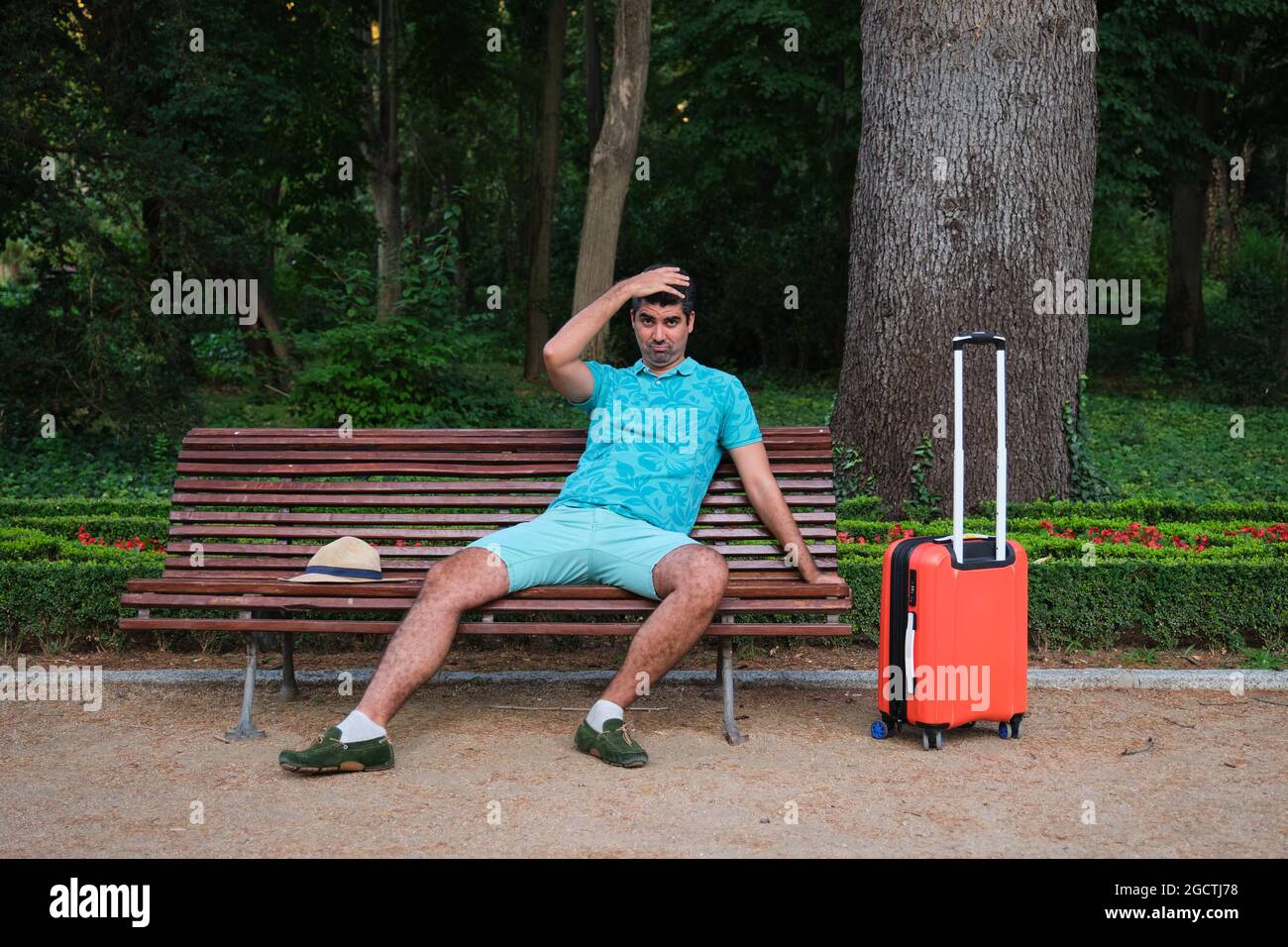 Tourist worried because he has lost his flight, bus, train, sitting on ...