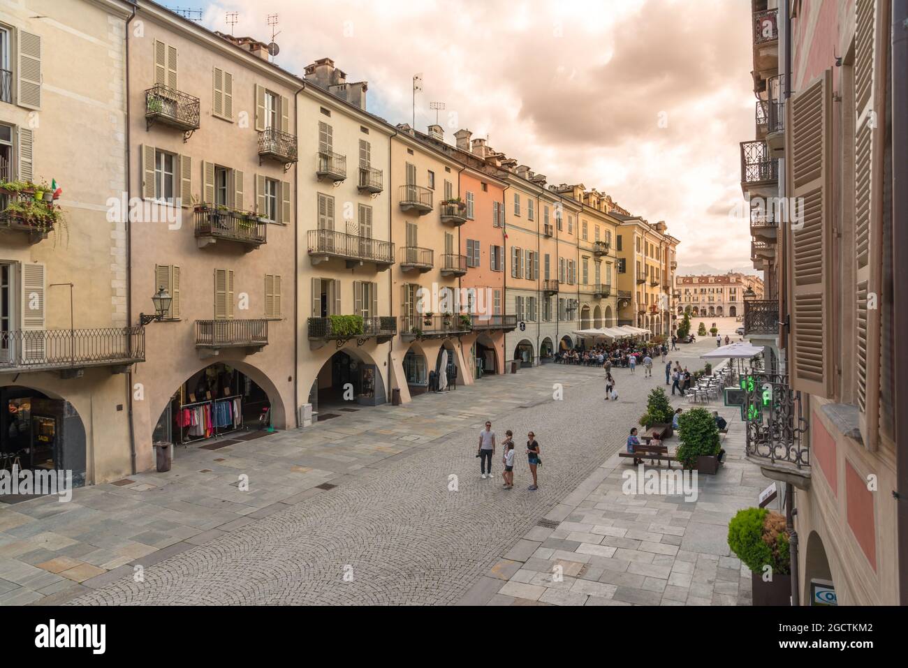 CUNEO, PIEDMONT, ITALY - AUGUST 2, 2021: Via Roma at sunset with historic colorful buildings with arcades (portici of Cuneo), Galimberti square in the Stock Photo