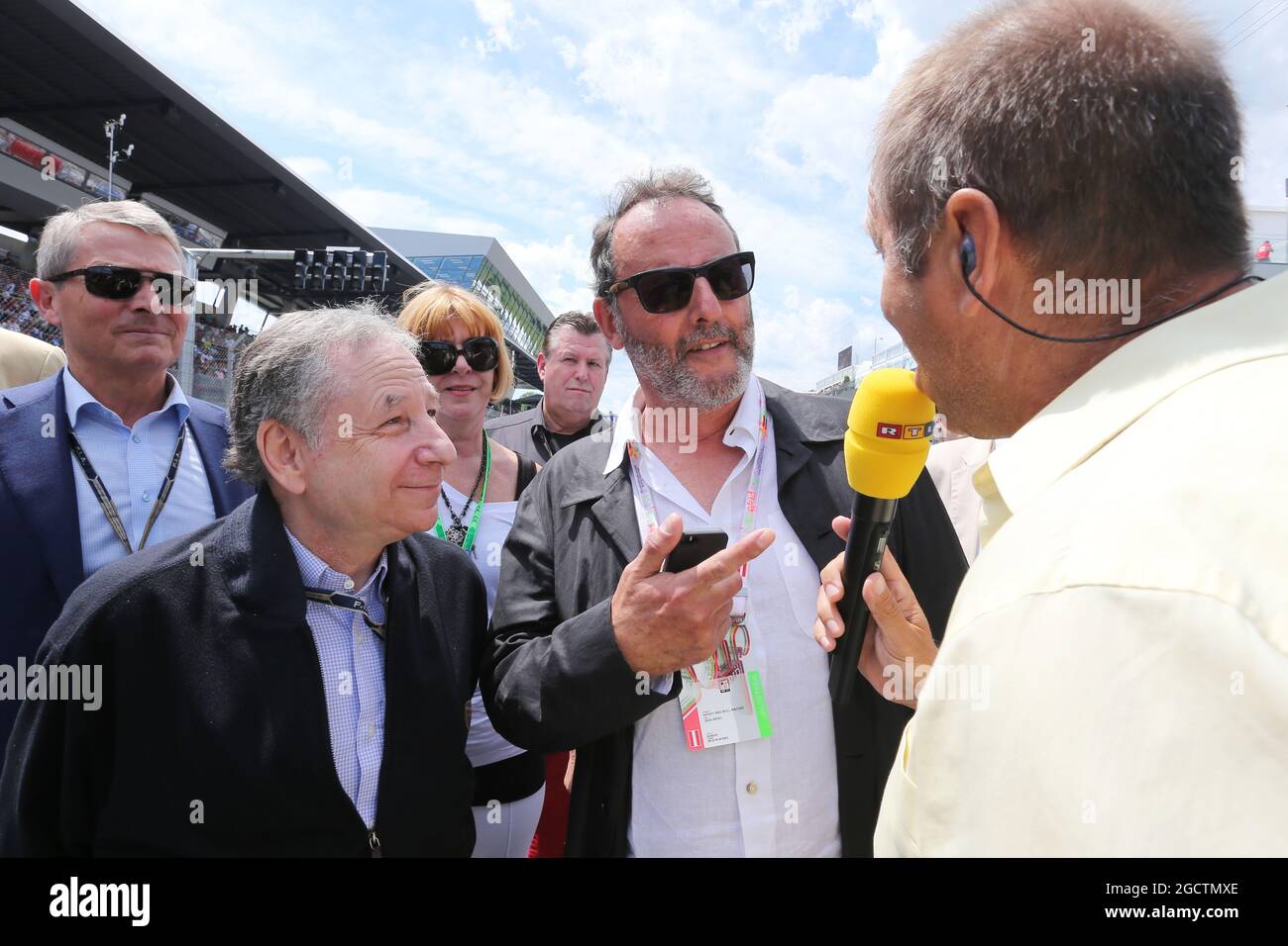 (L to R): Jean Todt (FRA) FIA President on the grid with Jean Reno (FRA) Actor and Kai Ebel (GER) RTL TV Presenter. Austrian Grand Prix, Sunday 22nd June 2014. Spielberg, Austria. Stock Photo