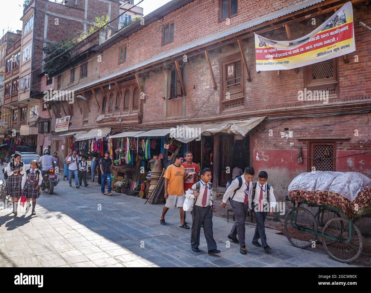 Nepalese schoolboys and schoolgirls in uniform coming home after school in Kathmandu, Nepal Stock Photo