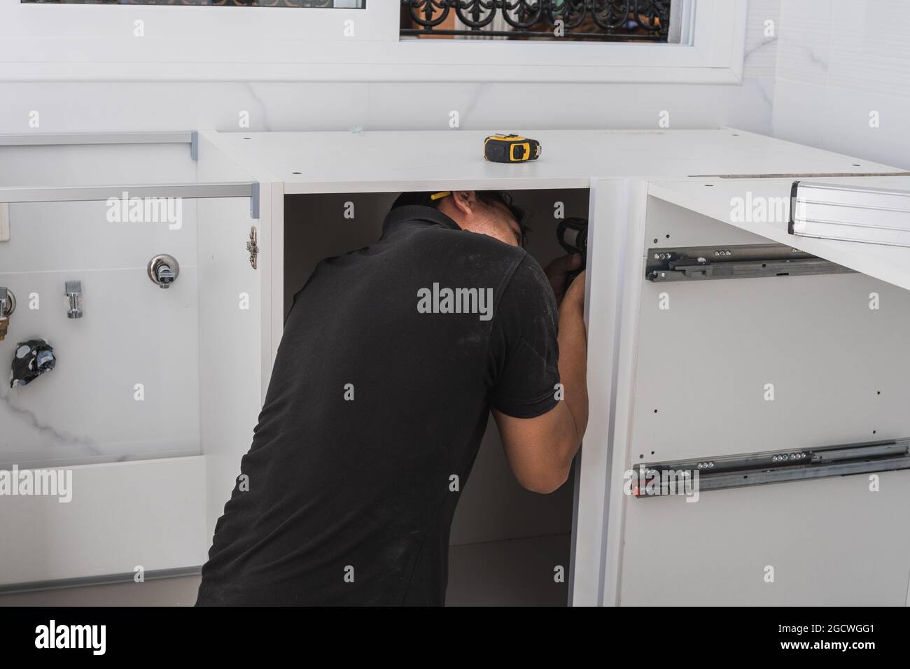 Man assembling a kitchen cabinet Stock Photo