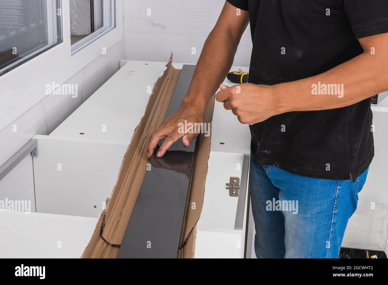 Man with black pieces of a cabinet ready to be assembled Stock Photo