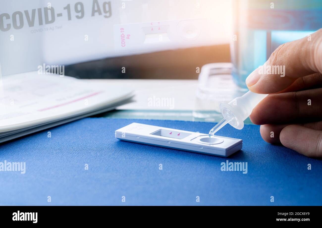 Hand holding sample tube and drops in the test device of covid 19