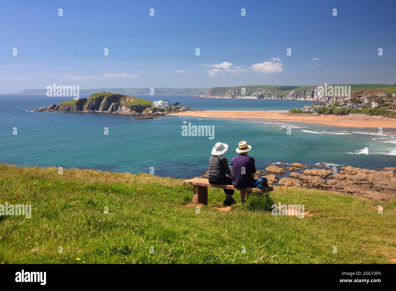 Seated couple looking over Bigbury-on-Sea and Burgh Island, Bigbury-on-Sea, South Hams district, Devon, England, United Kingdom, Europe Stock Photo