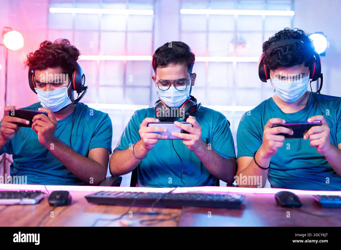 Group of gamers with medical face mask playing video game on mobile phone  at esports league or tournament during coronavirus or covid-19 with safety  Stock Photo - Alamy
