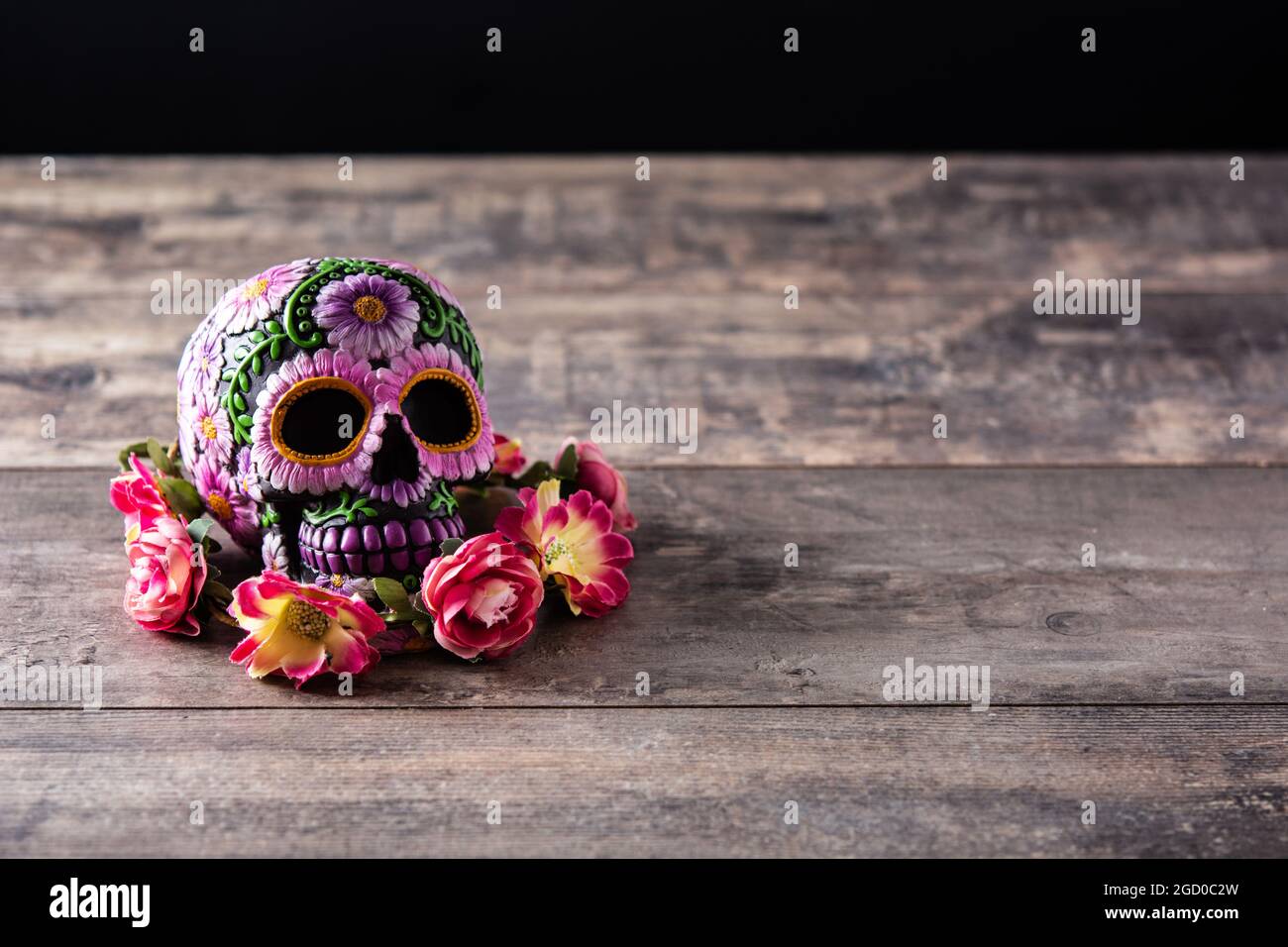 Typical Mexican skull and flowers diadem on wooden table. Dia de los muertos. Stock Photo