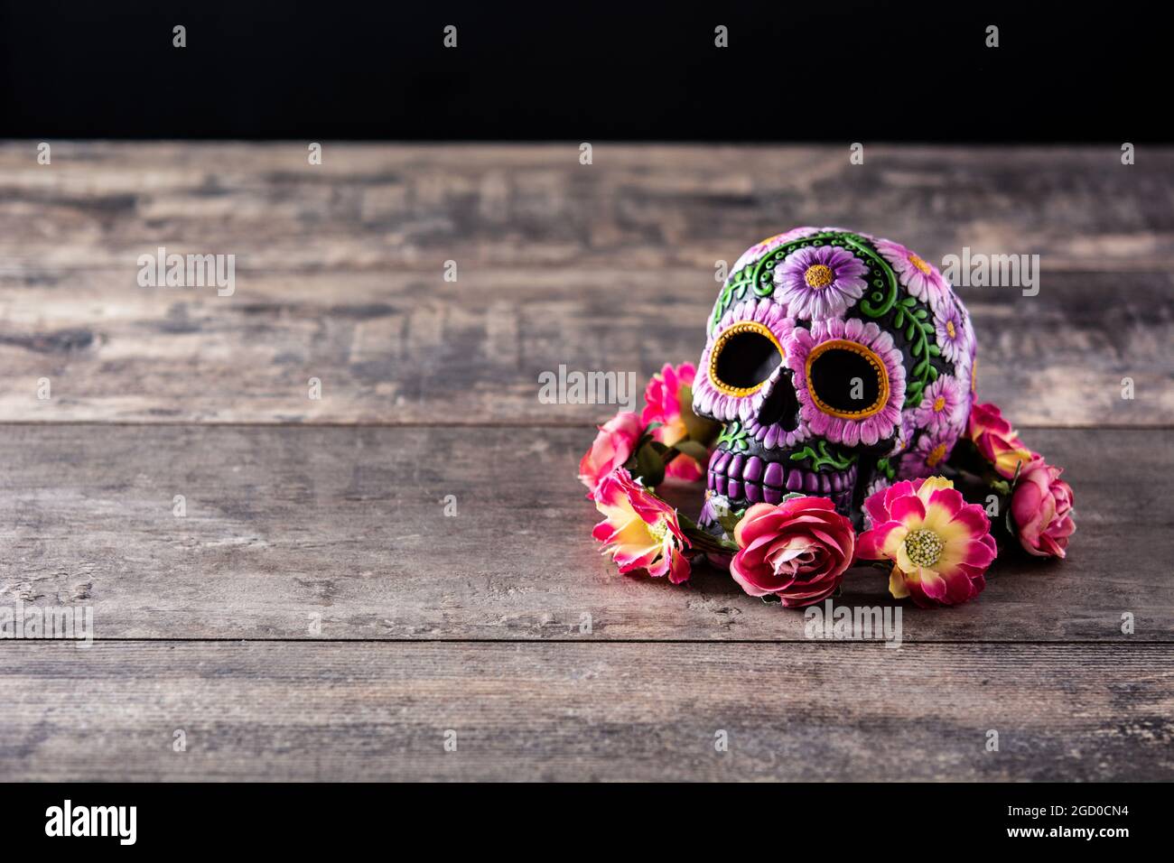 Typical Mexican skull and flowers diadem on wooden table. Dia de los muertos. Stock Photo