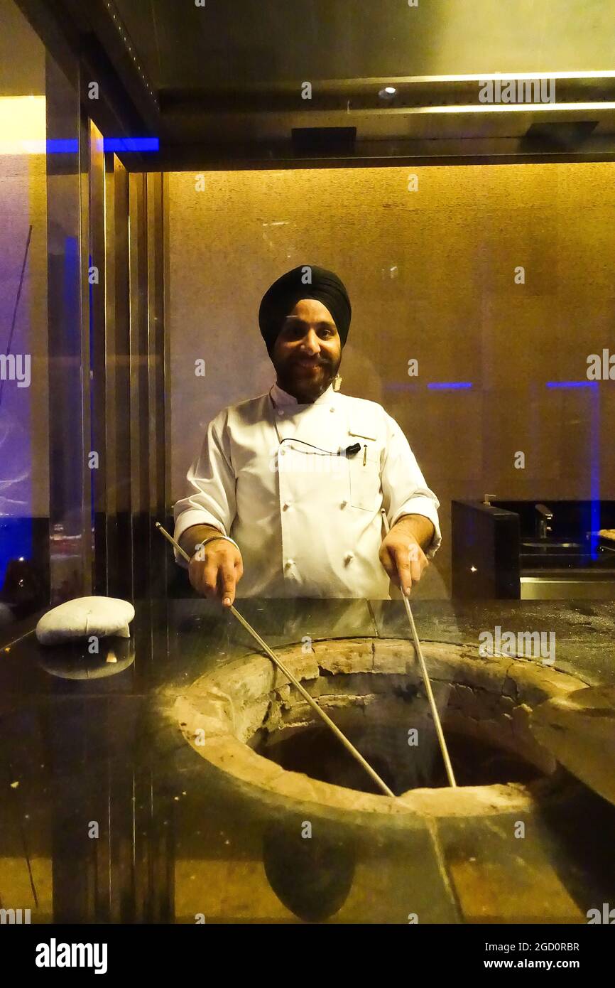 Cook at the Ananta Indian Restaurant of The Oberoi Hotel in Dubai at a Naan Bread Oven Stock Photo