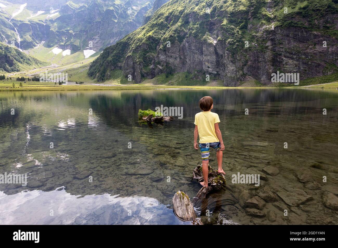 Boy standing on a rock on at the Hintersee lake in Mittersill Salzburg Austria Stock Photo