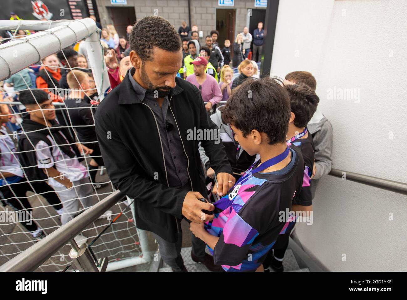 Rio Ferdinand Signing Autographs During The Bt Hope United Match At Crusaders Fc Seaview Grounds In Belfast On The Eve Of The Super Cup To Raise Awareness About The Devastating Impact Of
