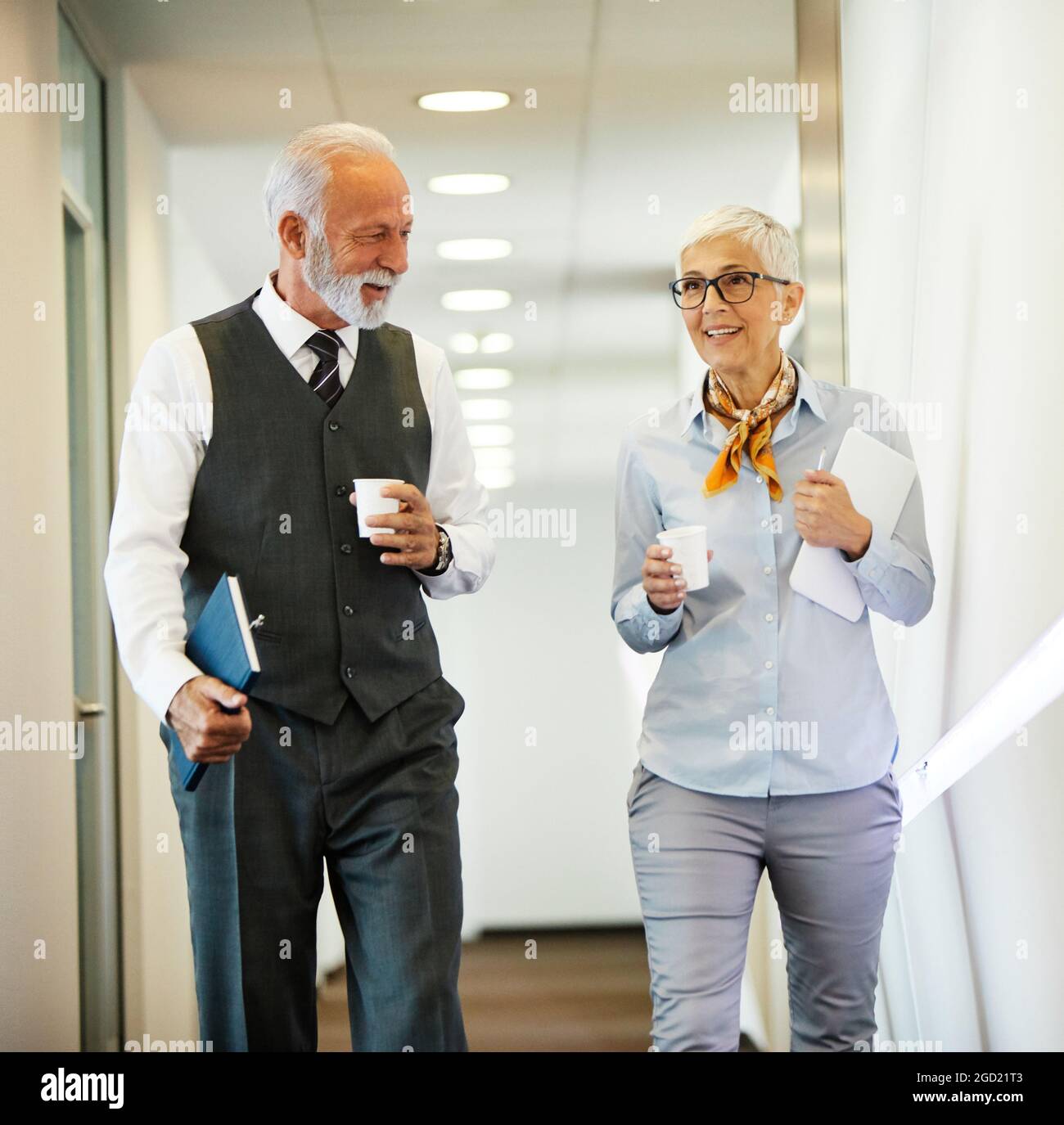 business office discussion teamwork senior meeting businessman businesswoman man woman break coffee Stock Photo