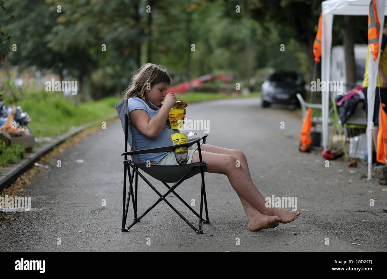 Illustration shows a girl of the Family 'Vos', eating instant noodles in a chair, the family is living near a destroyed camping site in Esneux, Tuesda Stock Photo