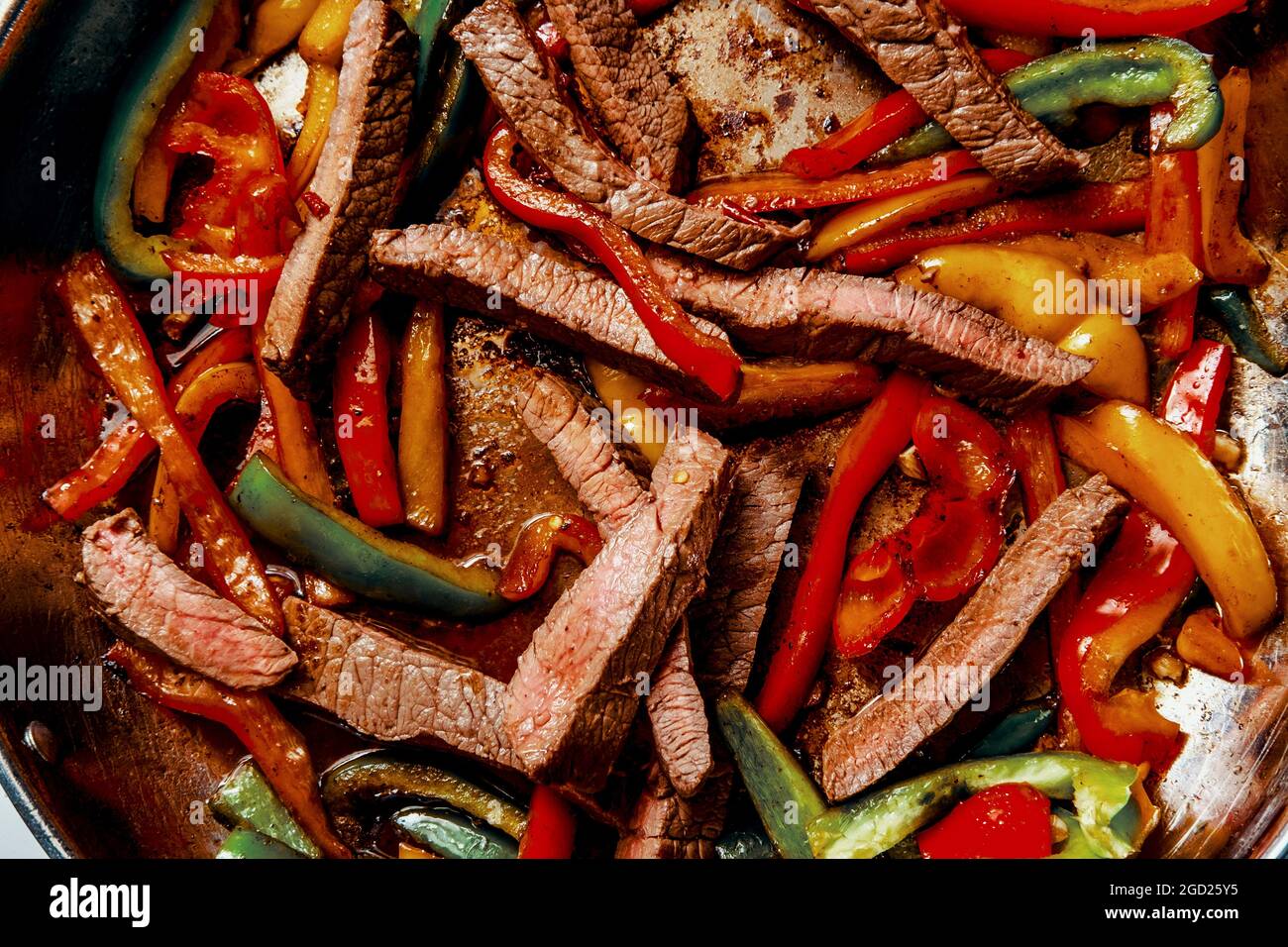 Cooking Mexican top round steak fajitas in giant pan on stovetop Stock
