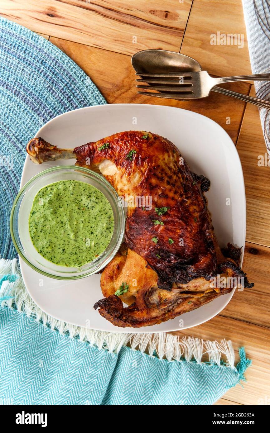 Peruvian roast chicken leg dinner with green sauce Stock Photo Alamy