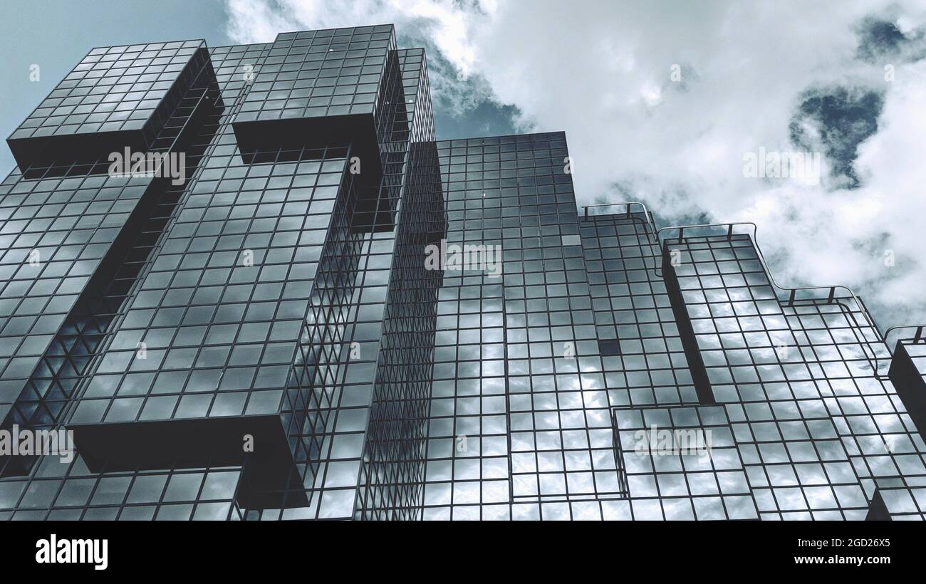 Low angle shot of the reflection of the sky on a tall glass building ...